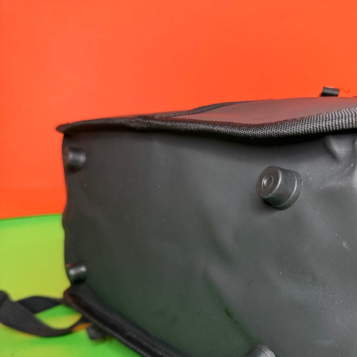 Black bag base with plastic feet  on a colorful background Expandable black rolltop backpack showing rolled and unrolled capacity