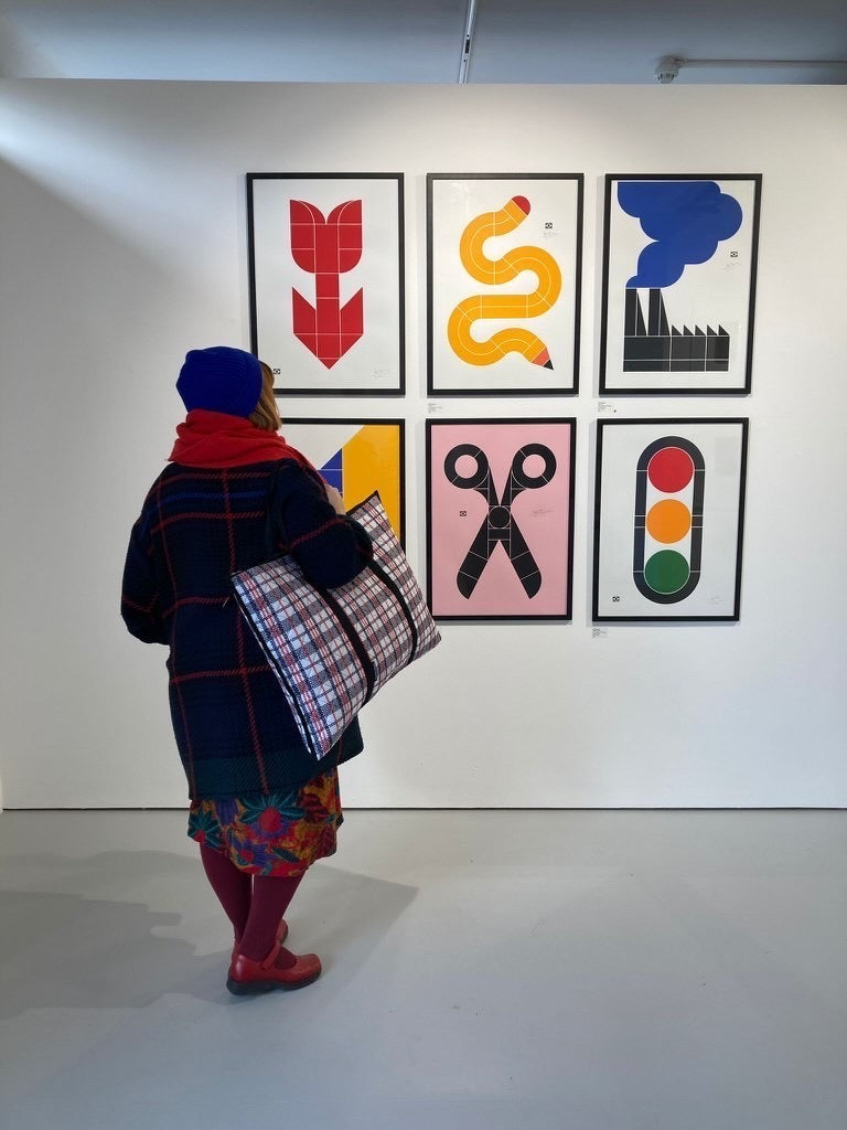 tartan oversized bag in an art gallery held by a woman wearing a scarf and hat