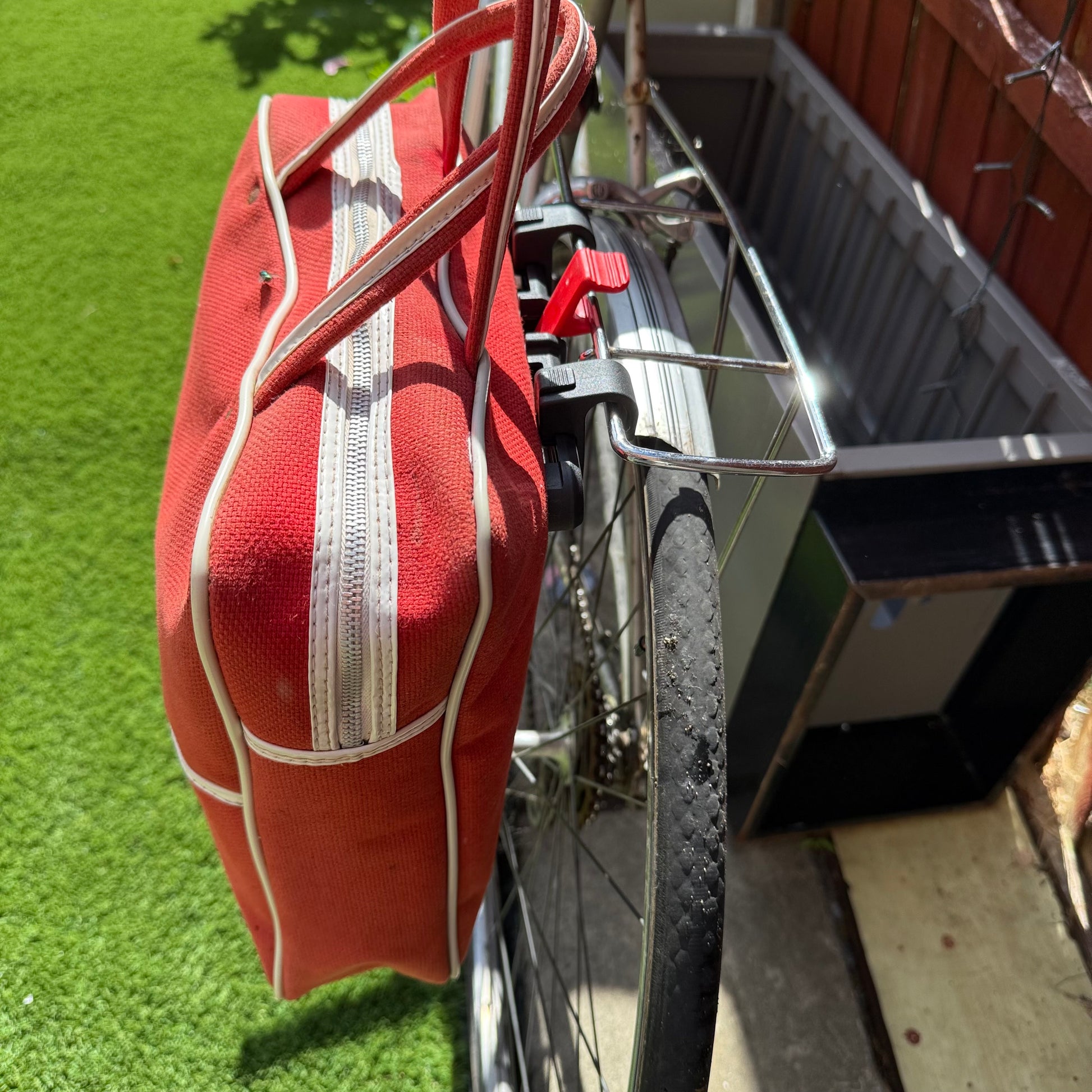Red vintage travel bag used as a sustainable bike pannier