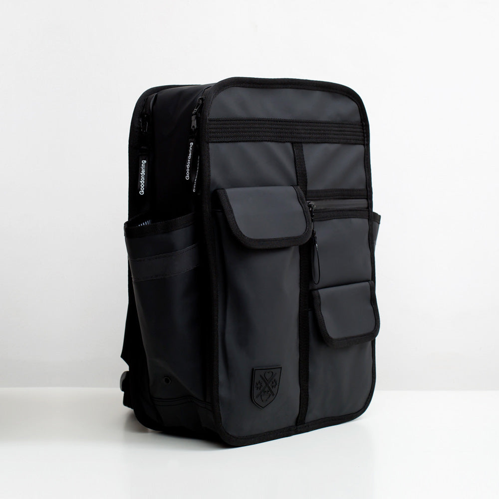 Matt black boxy backpack with outside side pockets and two front velcro pcokets and one zip pocket. Laptop pocket and waterproof material. Monochrome rucksack Goodordering